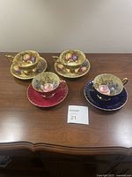 Overview of four tea cup and saucer sets on table