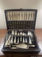Full view of open wood case showing organized flatware set.
