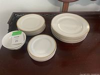 Full set of plates and bowl on wooden surface showing different sizes and overall condition