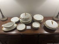 Photo showing full set arranged on wooden surface including covered soup tureens, plates stacked, gravy boat, serving bowls, saucers, and bread plates