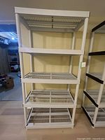Full front view of white plastic shelving unit with 5 shelves.
