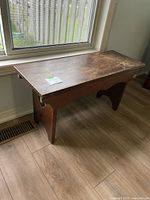 Bench positioned by window, showing full side profile and top surface wear.