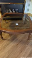 Full top view of the square wooden coffee table showing glass insert and wooden frame.