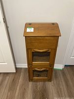 Front view showing entire wooden vegetable storage box with hinged top and two mesh panel doors below.