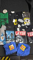 Front view of all 10 new size small t-shirts with tags, showing various graphics including Guardians of the Galaxy, Mario, Minion eye, and other designs.