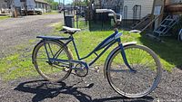 Full side view of blue Sears by Murray 26 inch women's bicycle showing frame, wheels and handlebars.