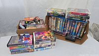 Photo showing the full collection of 41 VHS movies arranged in three groups; includes a variety of Disney and kids movies, as well as some titles with Blockbuster branding.