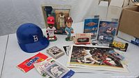 Full lot showing signed blue baseball helmet, bobbleheads, sealed Phillies 2009 card set, diecast cars, sports photos and boxed Allen Iverson figure