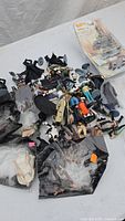 Star Wars action figures and Hot Wheels cars scattered on a flat surface, showing multiple items in bulk with some packaged cars set to the side