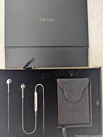 Top view of 1MORE headphones, carrying case, and box lid showing 1MORE logo