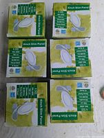 Six 4 inch slim panel LED light boxes stacked and arranged on a table, showing product name and some features on the boxes.