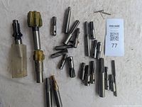 Overview of 19 assorted milling cutters and tooling bits, shown on a white surface with a paper label