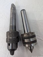 Photo showing two metal lathe accessories: Morse Taper #4 shaft fitted with an Ettco quick-change chuck and a live centre tool with pointed tip.