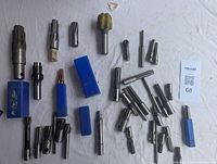 Top view of assorted milling cutters scattered on white surface with some in blue cases.
