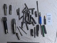 Photo showing an assortment of metal milling cutters and reamers in various sizes and styles laid out on a light surface with a MaxSold lot card visible.