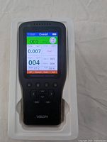 Front view of VSON air quality monitor powered on with screen displaying air quality data.