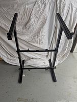 Full view of the black metal drafting table base standing upright showing the frame and supports.