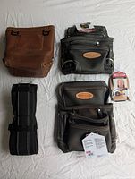 Five items arranged on white surface: two tool pouches, hammer loop pouch, hammer loop, padded belt, and extra fastener pouch.