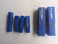 Five blue rectangular plastic cases labeled Proto-Cutter with model numbers, four cases closed and one cut in half for visibility.