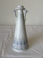 Front view of Marmorzellan German porcelain vase showing conical shape, hexagonal pattern on base, and twin sculpted handles.