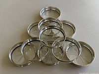 Stacked group of coasters showing silver rims and glass surfaces