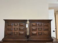 Pair of matching dark wood end tables with Brutalist carved fronts and metal handles shown side by side.