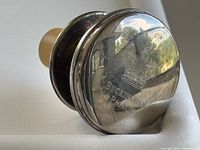 Angled close-up of top showing engraved crown emblem and 'Buckingham Palace' text