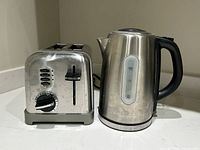 Front view of Dalton electric kettle and Cuisinart toaster showing kettle spout, handle, and toaster controls.