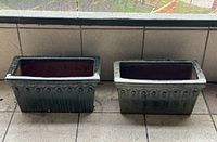 Pair of green glazed terracotta rectangular planters placed side by side on tiled floor, showing front and top views