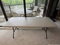 Full front view of Lifetime folding utility table with plastic surface and black metal legs in open position.