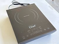 Full view image of the Master Chef induction cooktop showing the black glass cooking surface, single burner circle, and connected power cord.