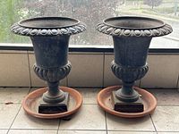 Front view of both planters side by side on tiled floor with terracotta saucers