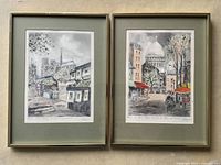 Pair of framed signed lithographs showing Paris street scenes, one featuring Notre Dame area with book stalls and the other Sacré-Cœur plaza with horse carriage.