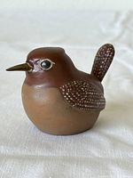 Side view of the brown and tan vintage bird figurine showing speckled wing and tail detail with yellow beak and prominent eyes.
