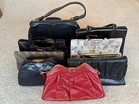 Collection of eight vintage women's evening bags and clutch purses in various styles and materials, showing wear consistent with age.