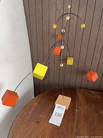 Front view of the mobile showing painted cubes and natural wood beads