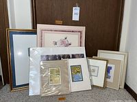 Photo showing the full lot of eight framed wall art pieces, varying sizes and designs, including prints with floral themes and decorative still lifes.