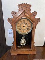 Full frontal image of the wooden gingerbread style wall clock showing intricate wood carving, measuring approx 20 inches tall.