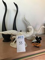 Overall view of ceramic white birds and Avon skunk cologne bottle