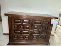 Front view of Drexel Et Cetera cabinet with geometric paneled double doors and latch.