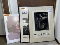 Three framed prints leaning against wall