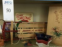 Photo of shelf showing vintage Radio Flyer mini wooden sled with red metal runners, ceramic Santa Claus dish, and a Christmas book titled 'The Bears' Christmas'