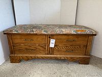 Front view of oak cedar chest with floral upholstered top