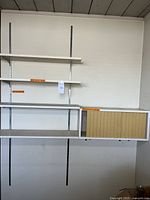Full view of the MCM shelving system mounted on the wall including shelves and cabinet with slatted front