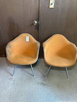 Front view of two chairs with orange covers on metal legs