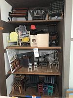 Front view of four shelves displaying 18 miniature chairs