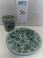 Photo of small cup with village houses and sailboat illustrations from Nymolle Art Faience, designed by Paul Hoyrup
