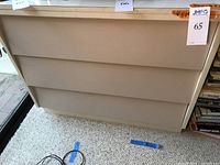 Front view of light beige 3-drawer wood dresser showing condition and design.