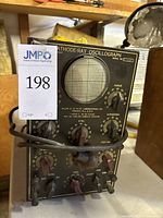 Overall view of front panel showing CRT screen, control knobs, and branding with auction tag visible.