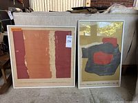 Two framed posters leaning against sofa